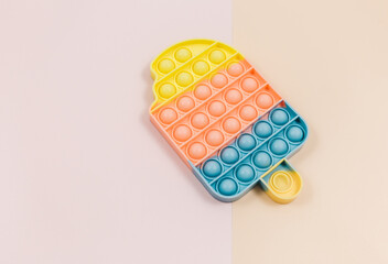 Popular silicone pastel anti stress pop it toy for child on pink background. Trendy Sensory Fidget Toy. Funny Bubble suitable for relieving stress for adults