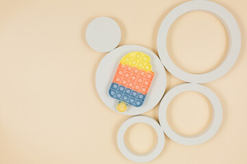 Popular silicone pastel anti-stress pop it toys and geometric shapes for a child on beige background. Trendy Sensory Fidget Toy. Funny Bubble suitable for relieving stress for adults