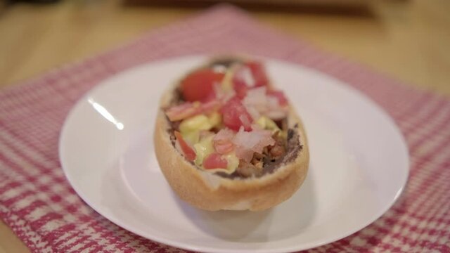 Traditional Mexican mollete on a plate above white and red checkered napkin