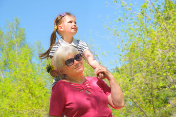 Loving cute granddaughter hugging her grandmother. Happy family.  Having good times with grandparent outdoors