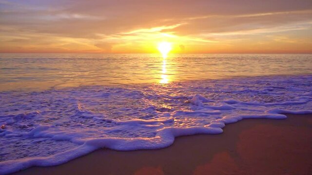 Dramatic sea sunset or sunrise Burning purple sky and shining white waves crashing on sandy shore Beautiful light reflection on sea surface Amazing landscape or seascape background