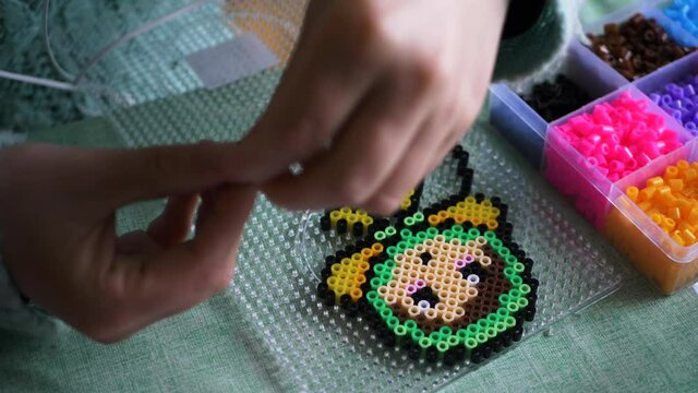 Closeup Of A Female Making A Colourful Babushka Design From Ironing Beads