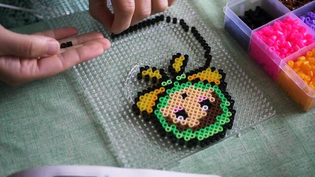 Closeup Shot Of Hands Creating A Babushka Design From Ironing Beads, Arts And Crafts