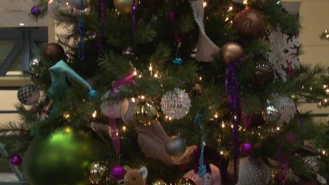 Decorated Christmas tree with snowflakes, balls and stuffed animals tilt down scanning shot