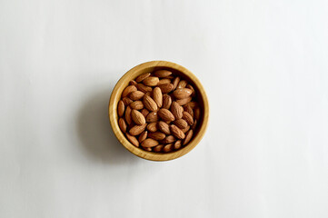 Top Views of Almond Nuts in a wooden bowl isolated on white background, Healthy Food Concept.