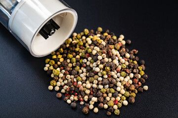 electric pepper shaker and peas on a black background.