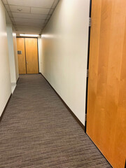 Long corridor or hallway  with a double door at the end.