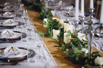 Long dining table, decorative candles, decorative leaves, decorative dishes decorative glass