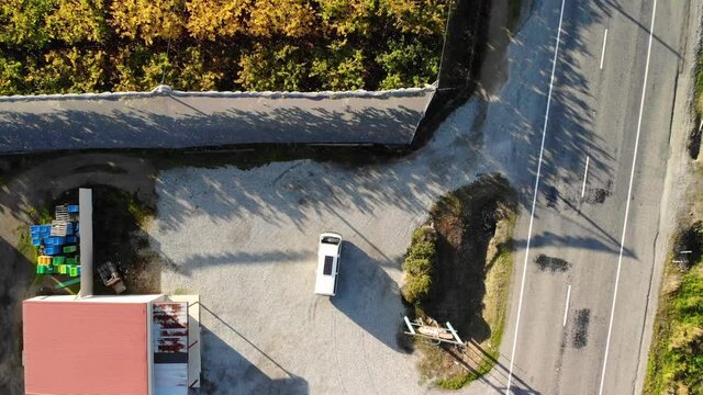 Man hitting the road and leaving cherry orchard, aerial look down