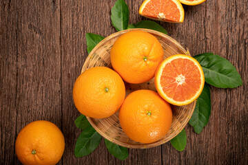 Fresh Oranges with Oranges slices on wooden Basket, Grapefruit or Cara Cara orange with leaves in...