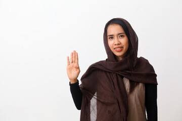 A portrait of happy asian muslim woman wearing a veil or hijab showing and pointing up with fingers number four while smiling confident. Isolated on white background with copy space