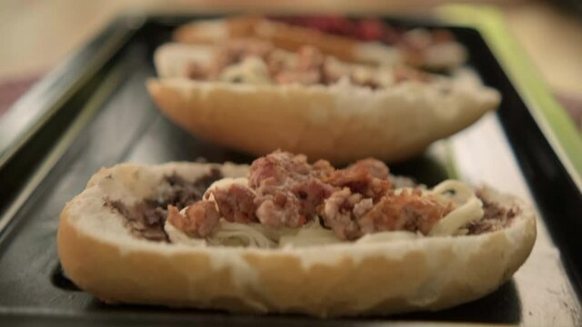 Three traditional Mexican molletes and a bowl of pico de gallo on a table
