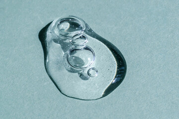 A drop of transparent cosmetic gel on a blue background.