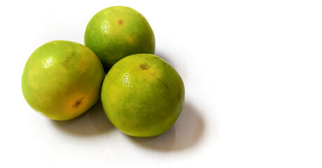 Three fresh green oranges on a white background. isolated green orange with copy space is suitable for a landing page or website.