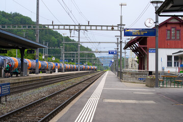 Fototapeta premium Empty platform at railway station Eglisau, canton Zurich, at summertime with cargo train. Photo taken June 9th, 2021, Eglisau, Switzerland.
