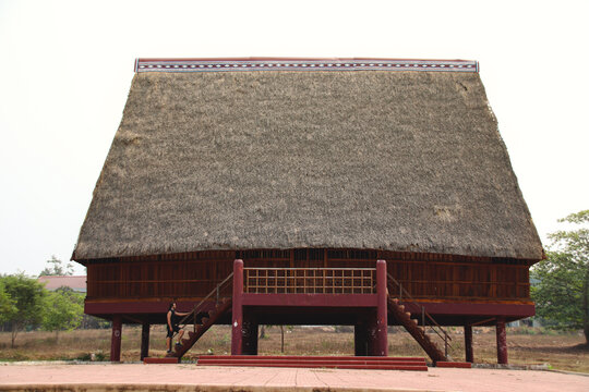 A tourist exploring a traditional architecture of a Bahnar ethnic stilt house or Rong House in Pleiku countryside, Vietnam
