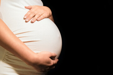 beautiful young pregnant woman on a black background