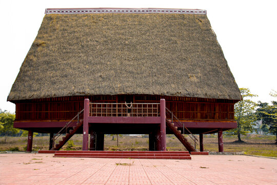 A tourist exploring a traditional architecture of a Bahnar ethnic stilt house or Rong House in Pleiku countryside, Vietnam