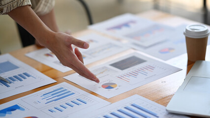 Cropped shot of businessman analyzing business data on wooden table.