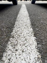 White parking lane line with two wheels in background