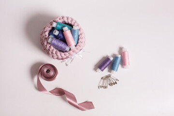 threads in a basket and locks for needlework and sewing on a light background