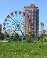 Ferris wheel in the children's town behind the red and blue fence, ulitsa Podvoyskogo, Saint Petersburg, RIossia, June 2021
