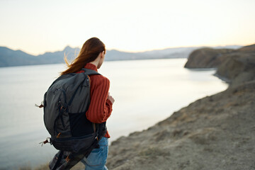 travel tourism young woman with backpack by the sea in the mountains nature