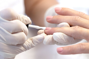 Manicure. Nail coating with colored gel polish by a manicure master in a beauty salon. The concept of professional nail care. Close-up