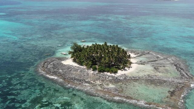 Aerial shot, circling Guyam Island. breathtaking small island with a reef, white sand beach and kind locals. Siargao Islands in the Philippines