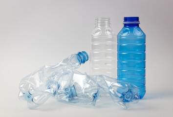 Plastikowe butelki na jasnym tle. Odpady z tworzywa sztucznego. - obrazy, fototapety, plakaty