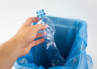 Segregacja plastikowych śmieci. Butelka plastikowa wrzucana do odpowiedniego kosza na śmieci. - obrazy, fototapety, plakaty