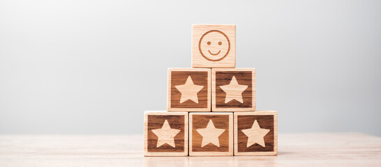 emotion face and Star symbol blocks on table background. Service rating, ranking, customer review, satisfaction, evaluation and feedback concept