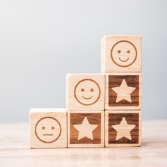 emotion face and Star symbol blocks on table background. Service rating, ranking, customer review,...