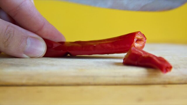Cutting Red Pepper with a knife. Red pepper is great spice for health, you can add it to your food or make drinks with it