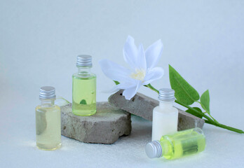 Body care product in the shower and shampoo with white flowers on a white background. The concept of daily skin care. Plastic bottle of shampoo with a floral fragrance. A simple example of a shampoo