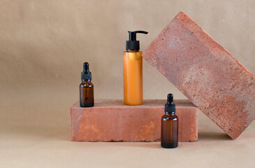 Brown glass bottles of cosmetics on stone, on beige paper background. Natural Organic Spa Beauty Beauty Concept Front View Layout