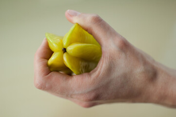 Female hands are holding exotic ripe starfruit or averrhoa carambola. Healthy food, fresh organic star apple fruit.