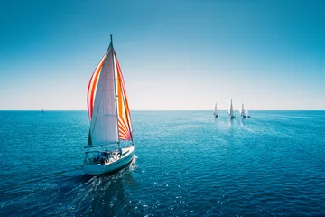 Deurstickers Regatta sailing ship yachts with white sails at opened sea. Aerial view of sailboat in windy condition © ValentinValkov