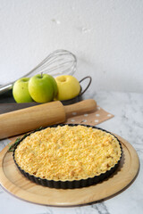 Apple crumble on the wooden background with apples .

