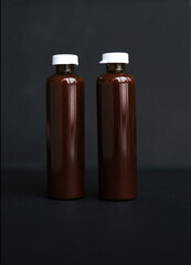 ampoules of liquid vitamin on a black background. bottles with cosmetic product on a dark background. glass medical ampoules. mockup