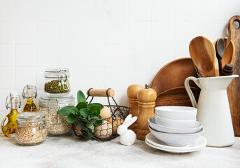 Kitchen utensils, tools and dishware on on the background white tile wall.