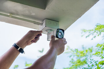 Technician installing wireless CCTV camera system on the building wall