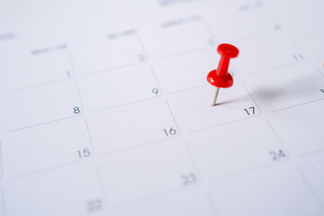 Fototapeta premium Selective focus. Picture of red pin embroidered on June 17 in the calendar.