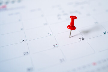 Selective focus. Photo picture of a calendar with a red pin on the 25th.