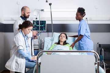 Obraz premium Practitioner doctors monitoring disease symptom writing recovery treatment on clipboard during medical appointment in hospital ward. Sick patient resting in bed recovering after surgery