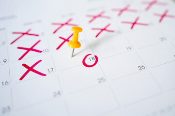 Pin with a red circle on the 18th on the calendar. Marking the date of the event with a pin.