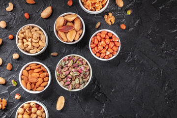 Nuts, healthy vegan snack, shot from the top on a black slate background with a place for text