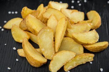 Peasant potatoes with salt on a black background