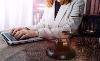 Justice and law concept.Male judge in a courtroom with the gavel, working with, computer and docking keyboard, eyeglasses, on table in morning light