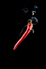 Cayenne chilli. Red hot chili paprika with hell flame, white smoke or spicy chile cayenne pepper...